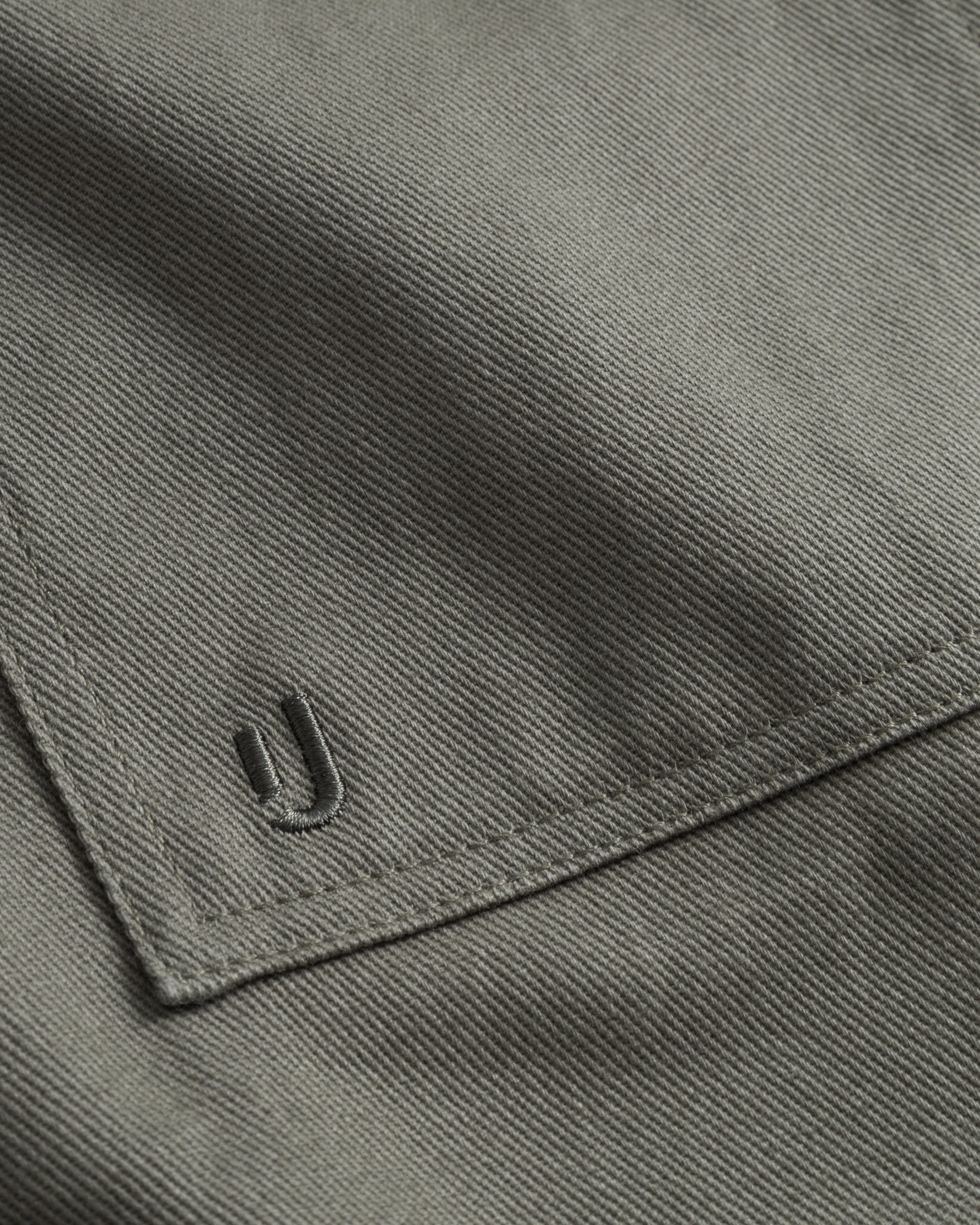 Detailaufnahme der grüngrauen Baumwoll-Overshirttasche 'Cameron' mit gesticktem Markenlogo