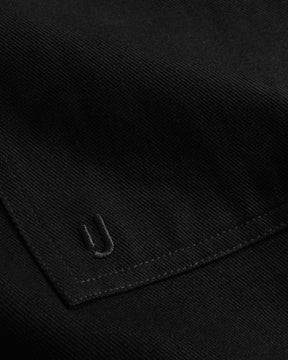 Nahaufnahme des schwarzen Overshirts 'Cameron' aus Baumwolle mit besticktem 'U' Detail