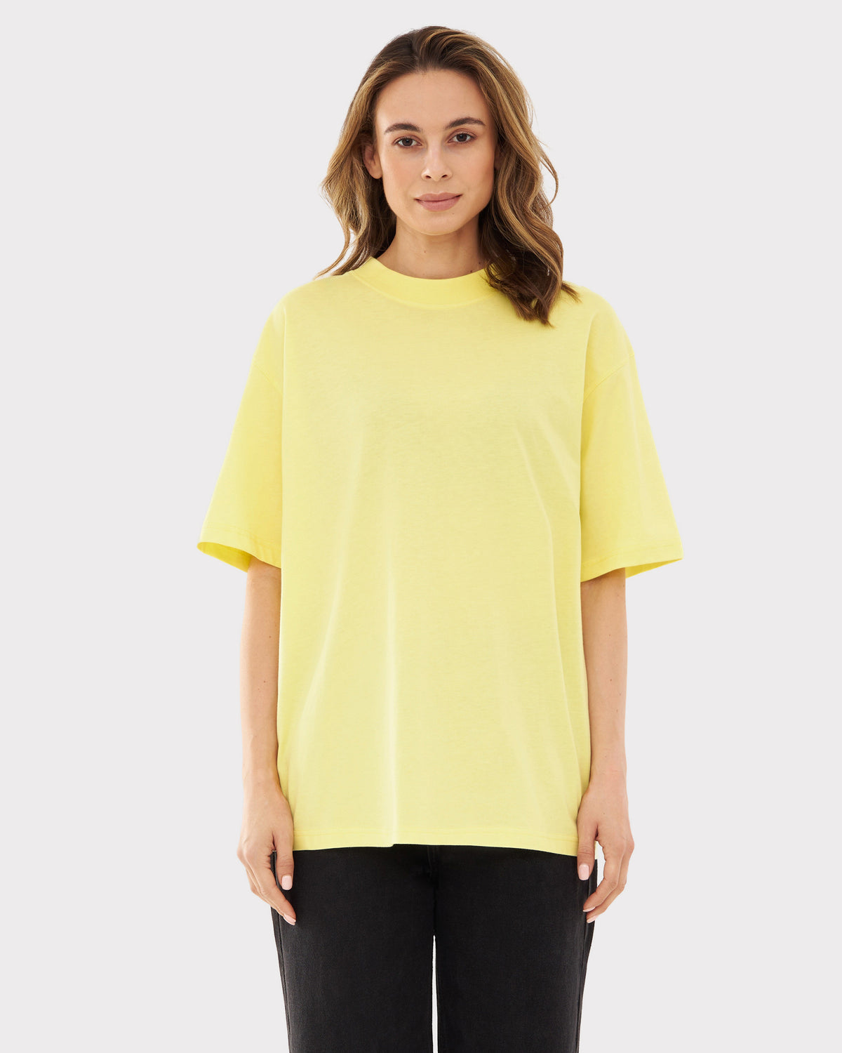 Frau trägt oversize gelbes T-Shirt 'Sammy JU' mit kurzen Ärmeln und schwarzer Hose