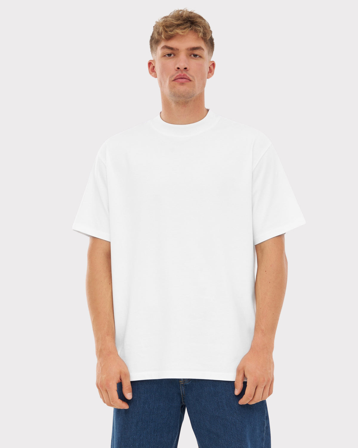 Mann trägt weißes Oversize-T-Shirt ohne Aufdruck und blaue Jeans