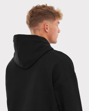 Rückansicht eines Mannes mit kurzem Haar, der einen schwarzen oversized Hoodie 'Cody' von Johnny Urban trägt