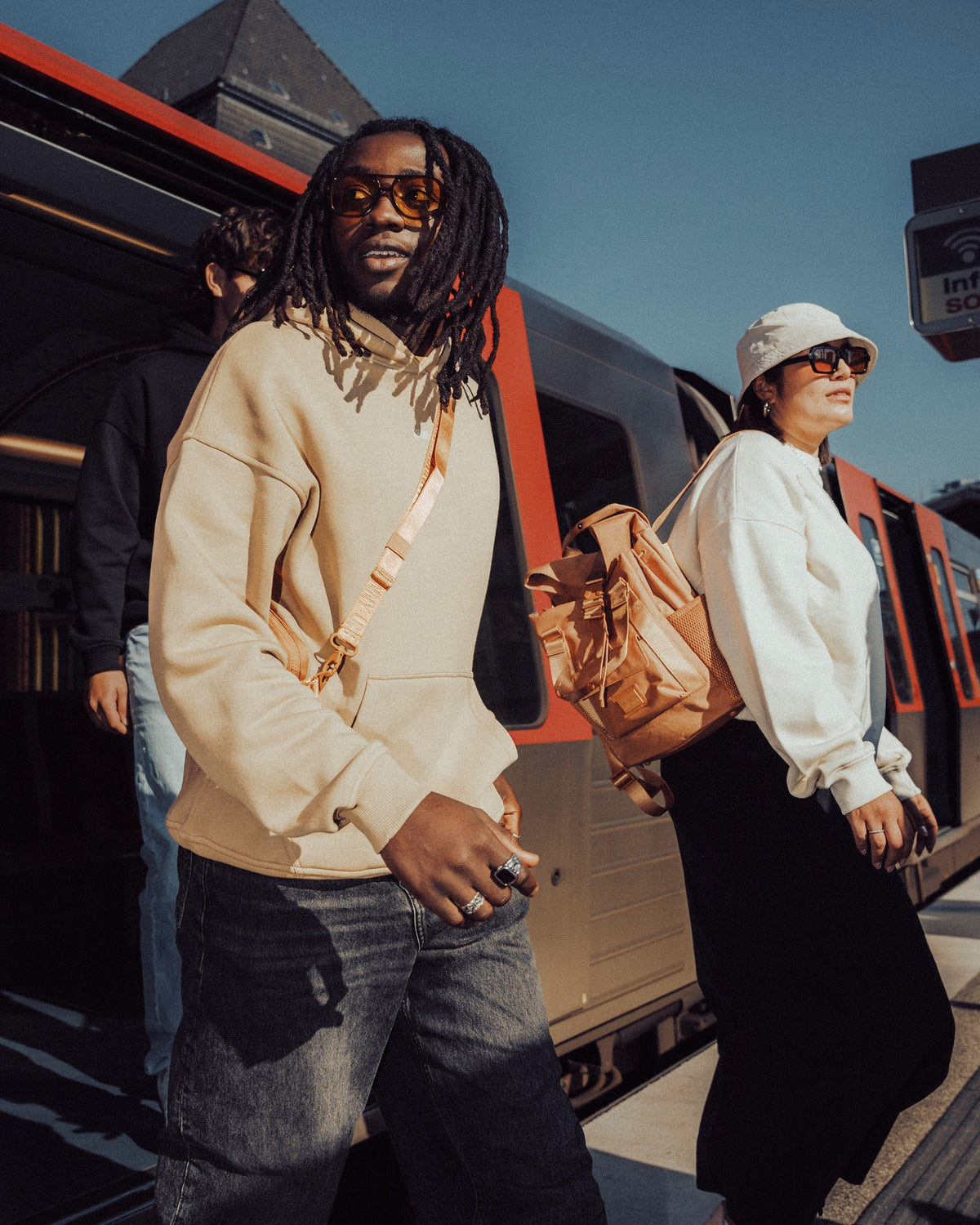 Person trägt beige oversized Hoodie 'Cody' von Johnny Urban mit Rucksack am U-Bahn-Bahnsteig