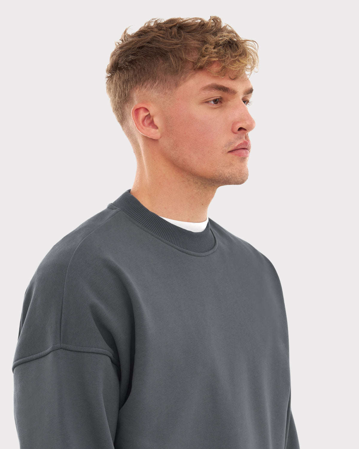 Mann trägt graues, oversized Crewneck Sweatshirt 'Carter' von Johnny Urban, seitliches Porträt