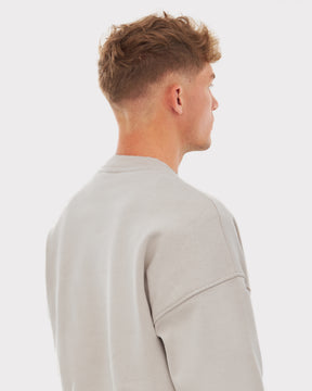 Mann von hinten mit kurzem hellbraunem Haar trägt beigen oversized Crewneck Pullover 'Carter' mit Raglanärmeln