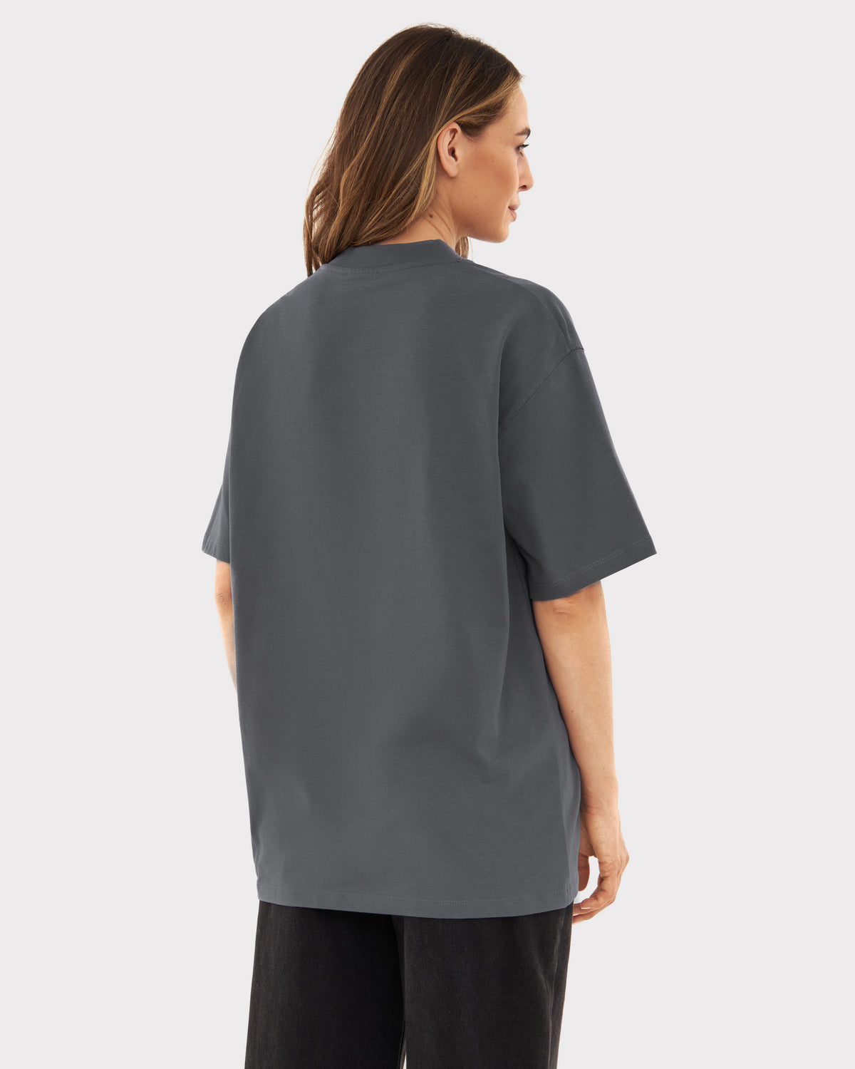 Damenmodell von hinten mit grauem, oversized T-Shirt Sammy und schwarzen Hosen