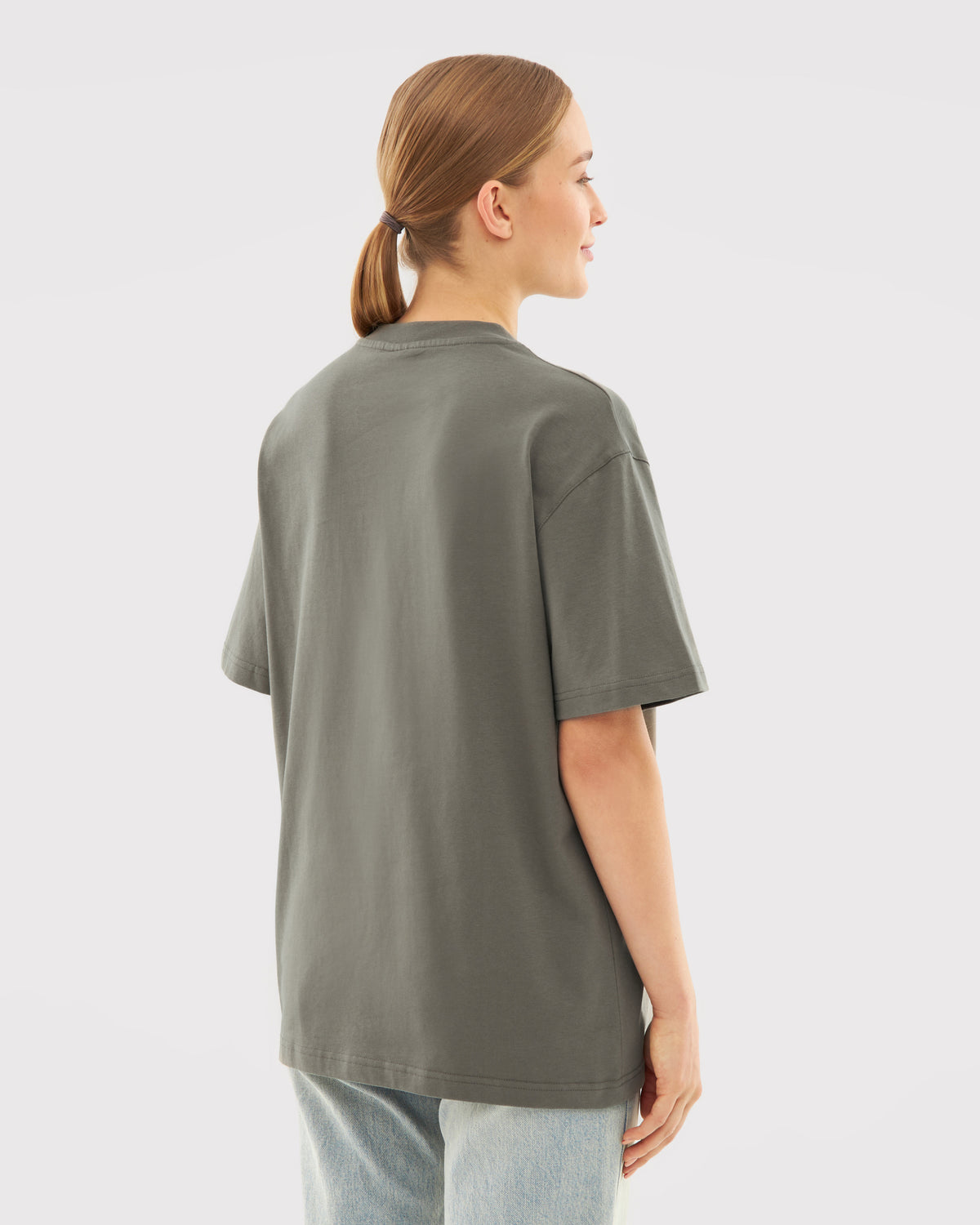Frau trägt oversized T-Shirt 'Sammy' in grauer Olive-Farbe, Rückansicht