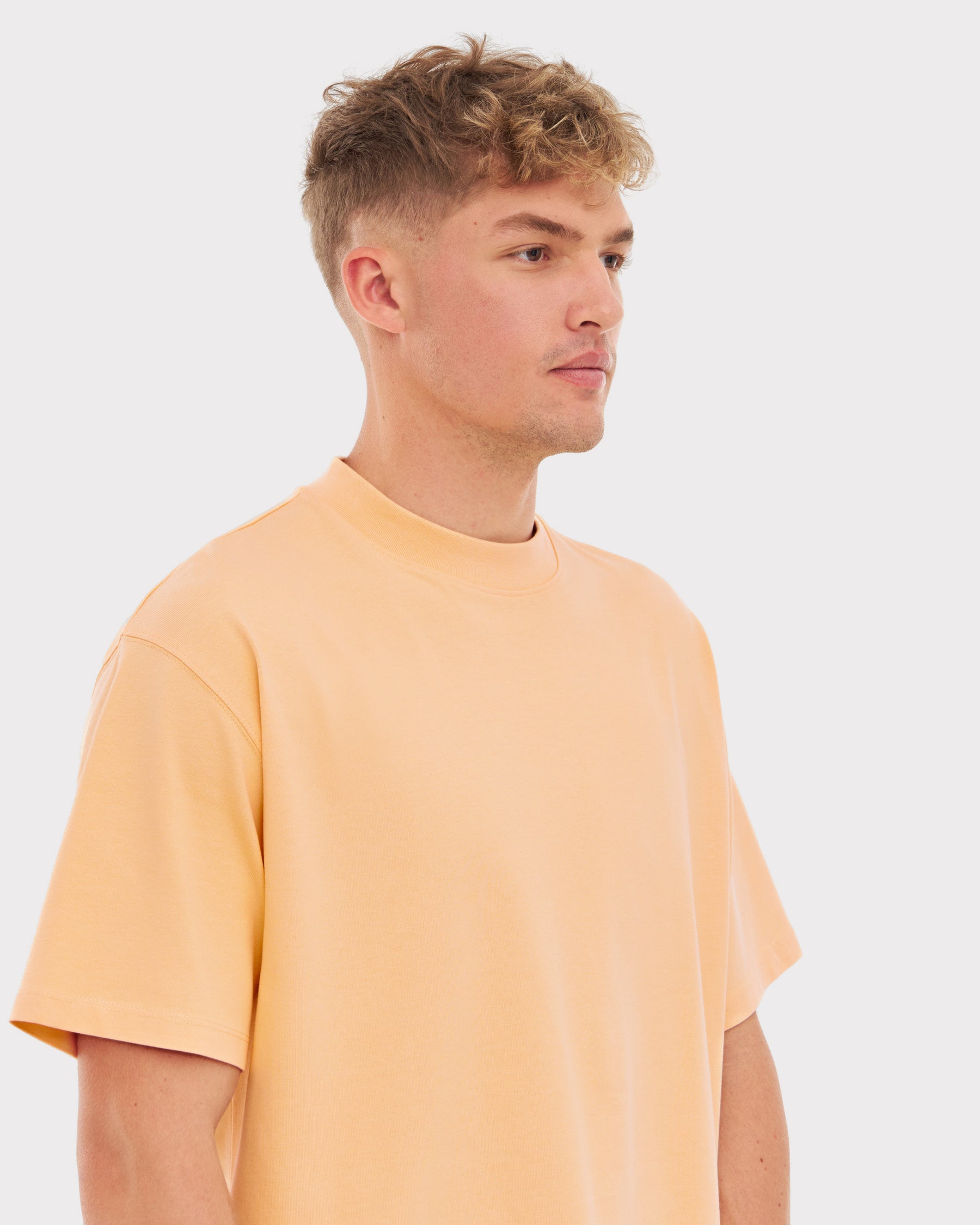 Mann trägt übergroßes T-Shirt ‚Sammy‘ in Pfirsichfarbe von Johnny Urban