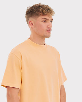 Mann trägt übergroßes T-Shirt ‚Sammy‘ in Pfirsichfarbe von Johnny Urban