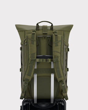 Olivgrüner Reiserucksack Allen XL Travel mit gepolsterten Schultergurten, Rückenpolster und Trolley-Hüllenband auf schwarzem Koffer