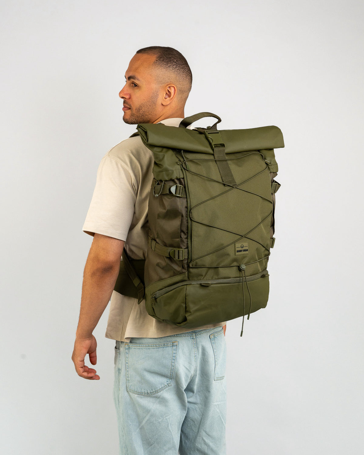 Mann mit Reiserucksack Allen XL Travel von Johnny Urban, olivgrün, großer Rolltop-Rucksack mit Außentaschen