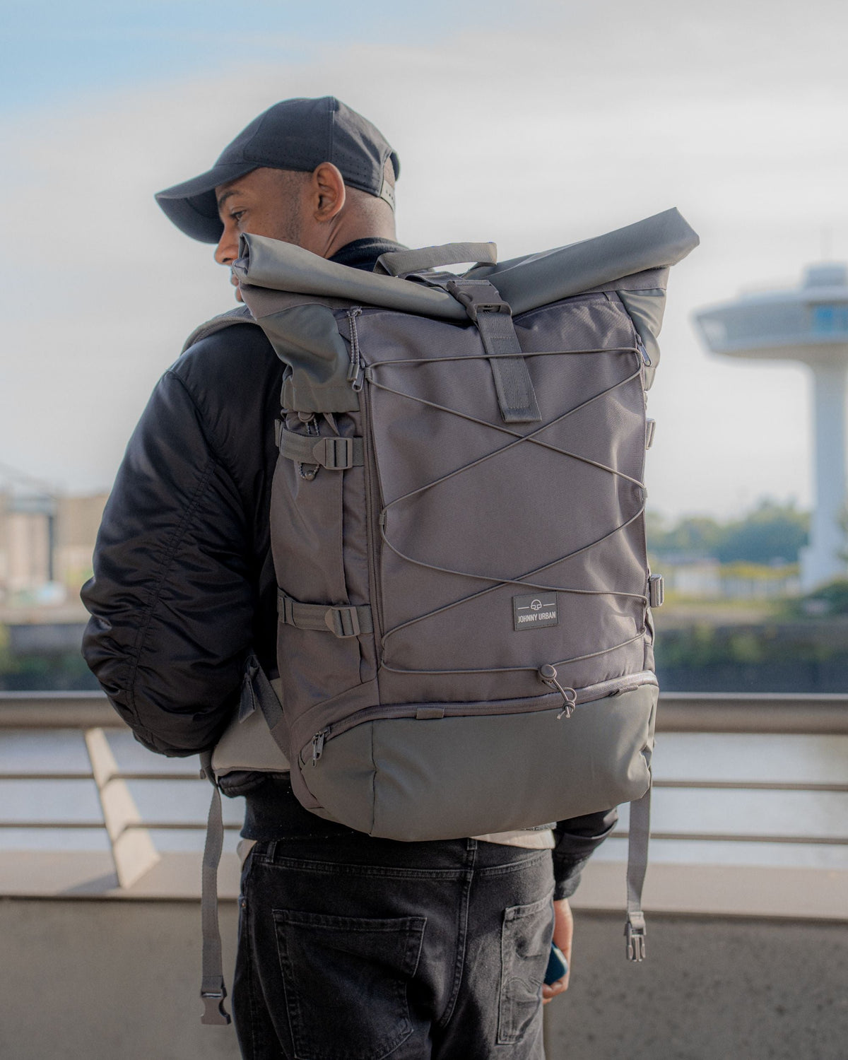 Mann trägt grauen Johnny Urban Reiserucksack 'Allen XL Travel' mit Rollverschluss und Außenspannbändern
