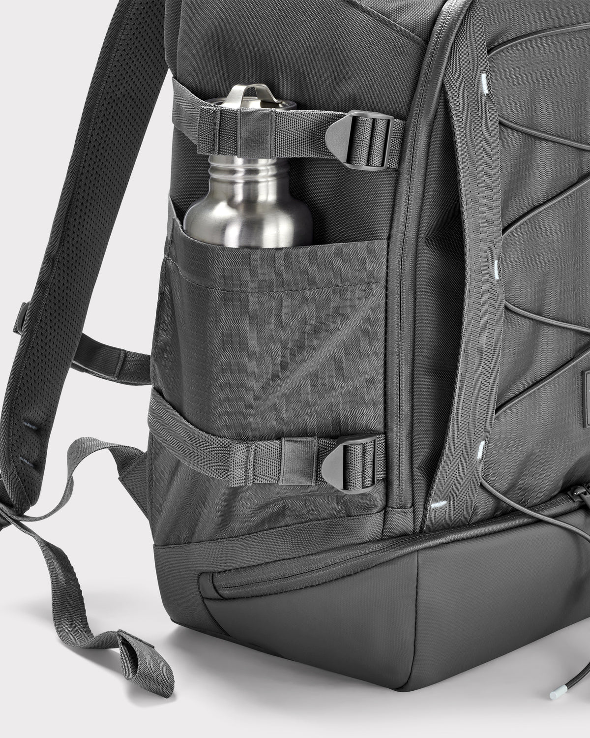 Seitliche Ansicht des grauen Reiserucksacks 'Jack' von Johnny Urban mit einer Metallflasche in der Außentasche und verstellbaren Riemen