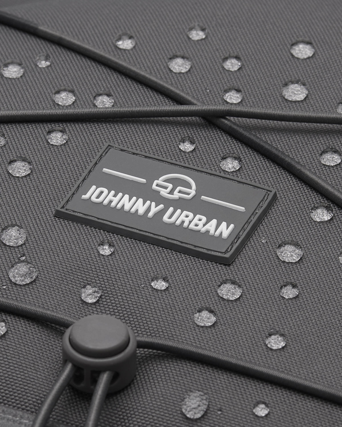 Nahaufnahme des grauen Johnny Urban Reiserucksacks 'Allen XL Travel' mit Wassertröpfchen auf dem Material