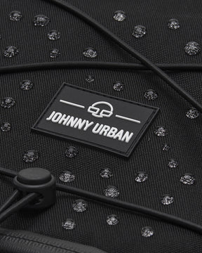Nahe Aufnahme des schwarzen, wasserabweisenden Reiserucksacks Allen Large Travel von Johnny Urban mit sichtbaren Wassertropfen