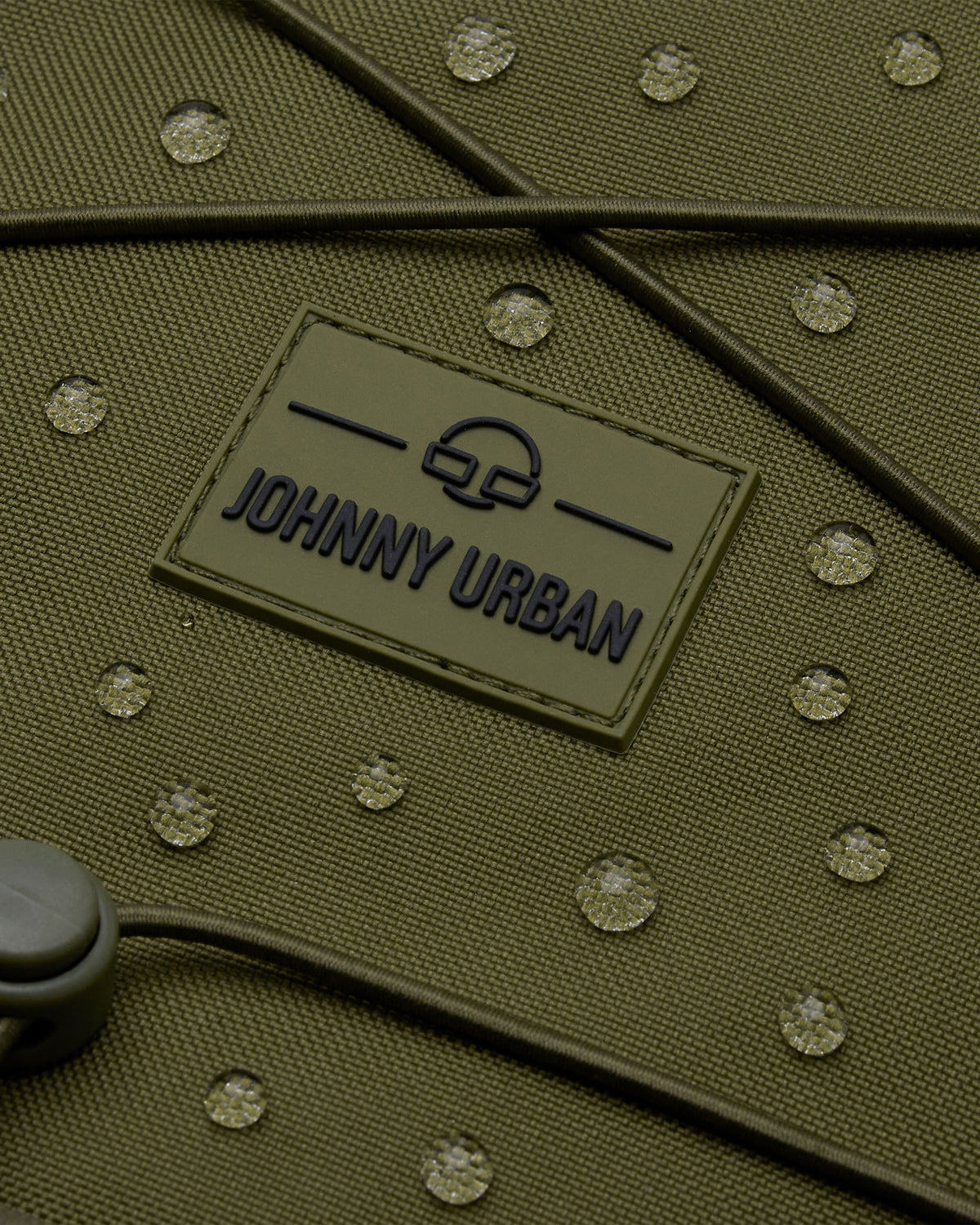 Aufnahme des olivgrünen Reiserucksacks 'Allen XL Travel' von Johnny Urban mit wasserabweisendem Material und sichtbaren Wassertropfen