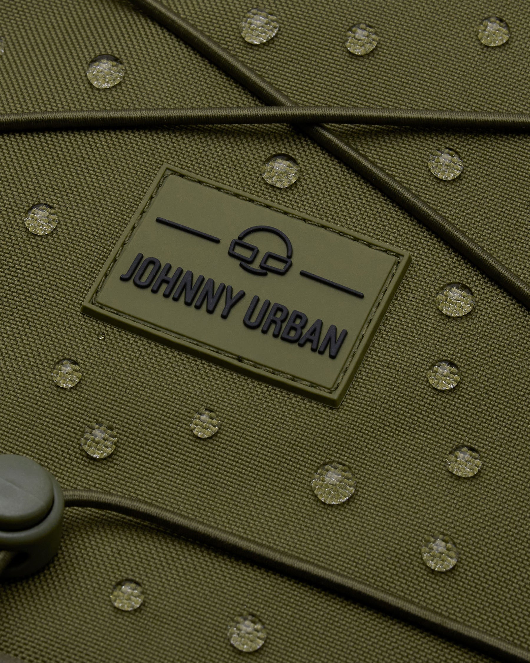 Aufnahme des olivgrünen Reiserucksacks 'Allen XL Travel' von Johnny Urban mit wasserabweisendem Material und sichtbaren Wassertropfen