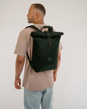 Mann von hinten mit beigem T-Shirt und blauem Jeans, trägt schwarzen Rolltop Rucksack 'Robin Medium' von Johnny Urban