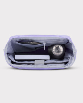 Offener lilafarbener Rolltop Rucksack Robin Medium mit Innenfächern, gefüllt mit Buch, Trinkflasche und Tablet