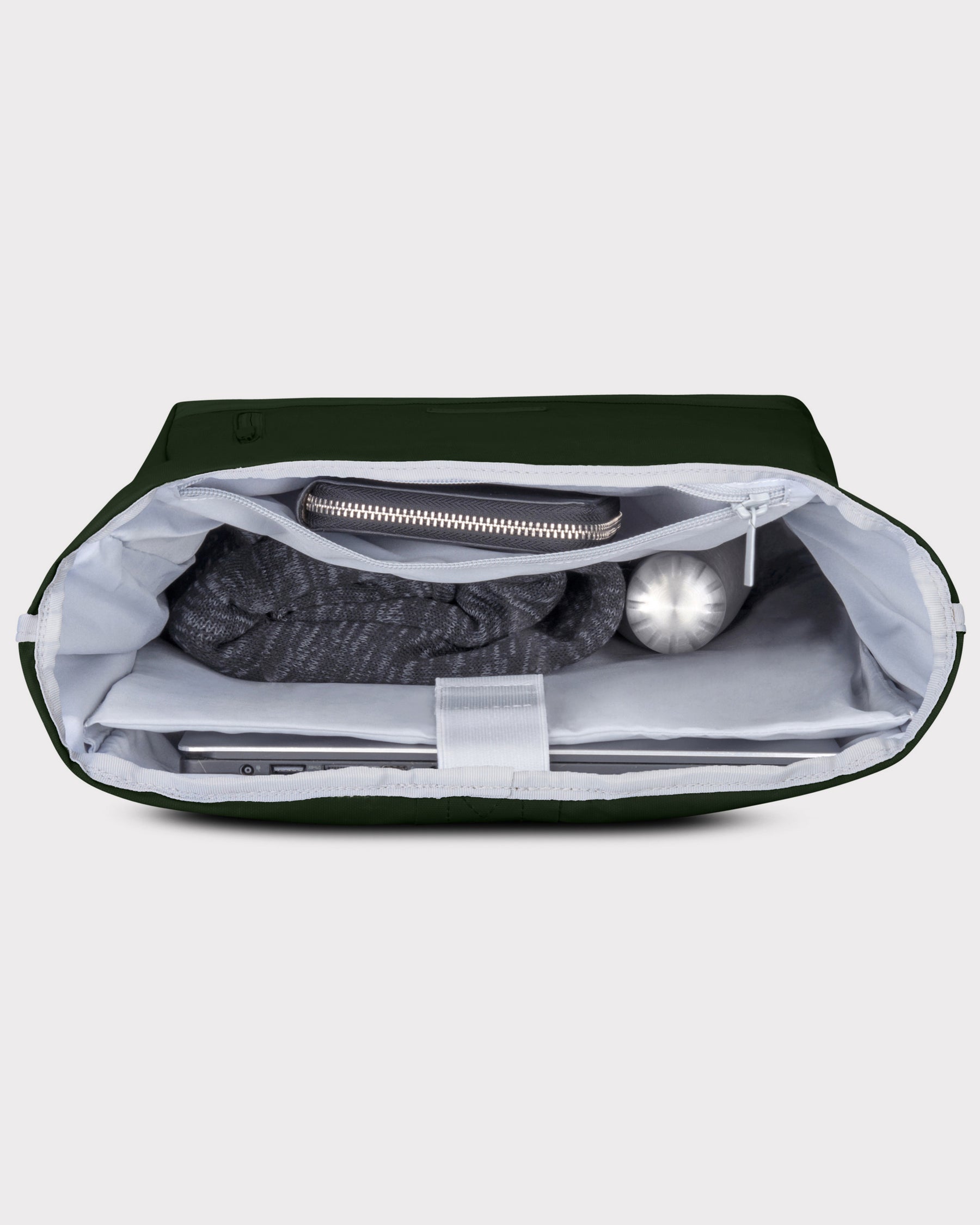 Geöffneter grüner Rolltop Rucksack 'Robin Large' von Johnny Urban mit Laptopfach, einem grauen Pullover, einer silbernen Flasche und einem Reißverschlussfach