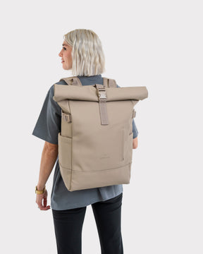 Frau mit beigefarbenem Rolltop Rucksack „Harvey Large“ von Johnny Urban, Rückansicht