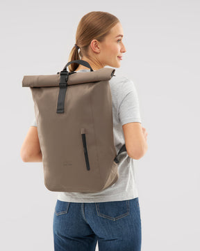 Beiger wasserfester Rolltop Rucksack 'Conor' von Johnny Urban auf dem Rücken einer Frau