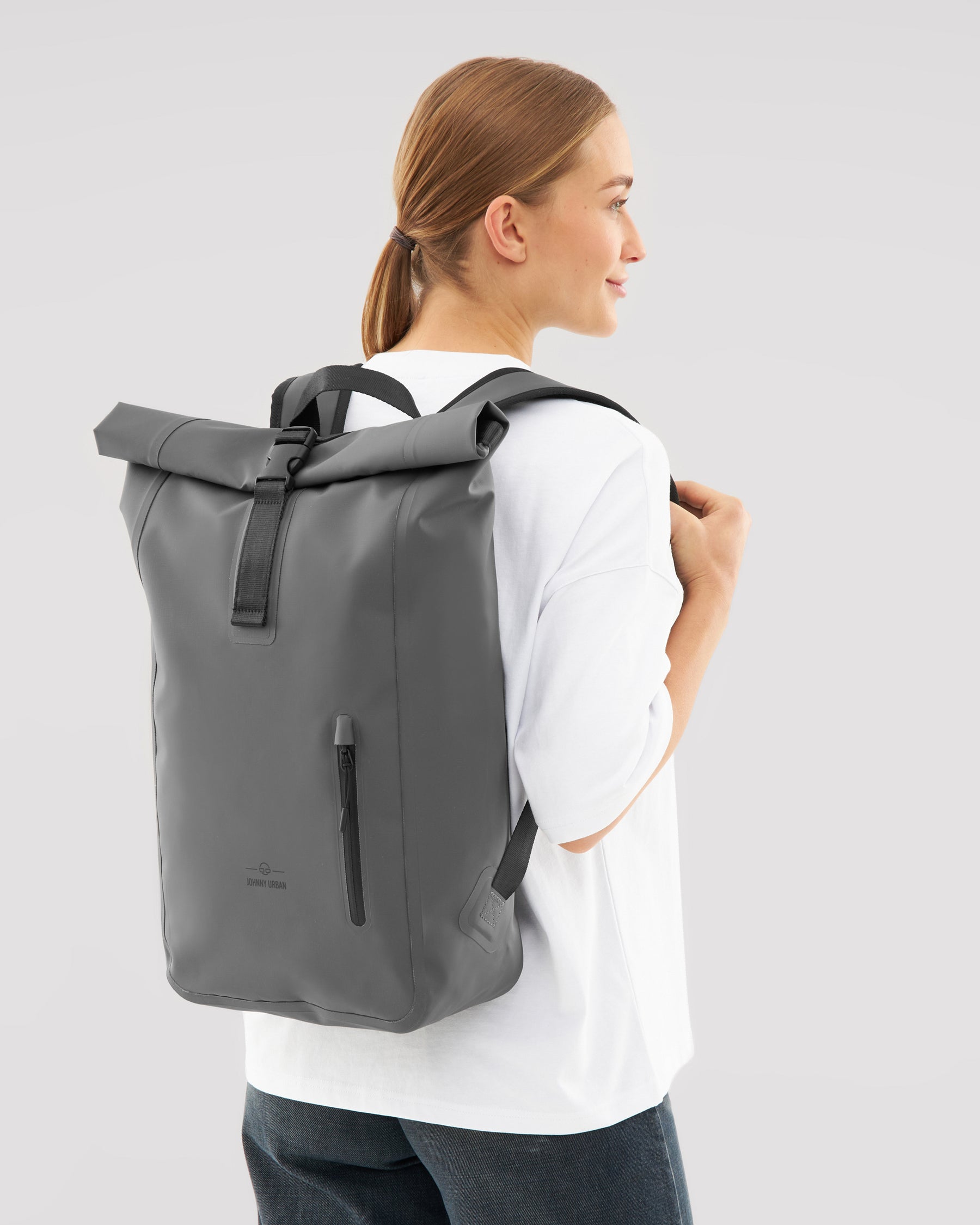 Frau trägt grauen wasserdichten Rolltop Rucksack 'Conor' von Johnny Urban mit schwarzem Verschluss