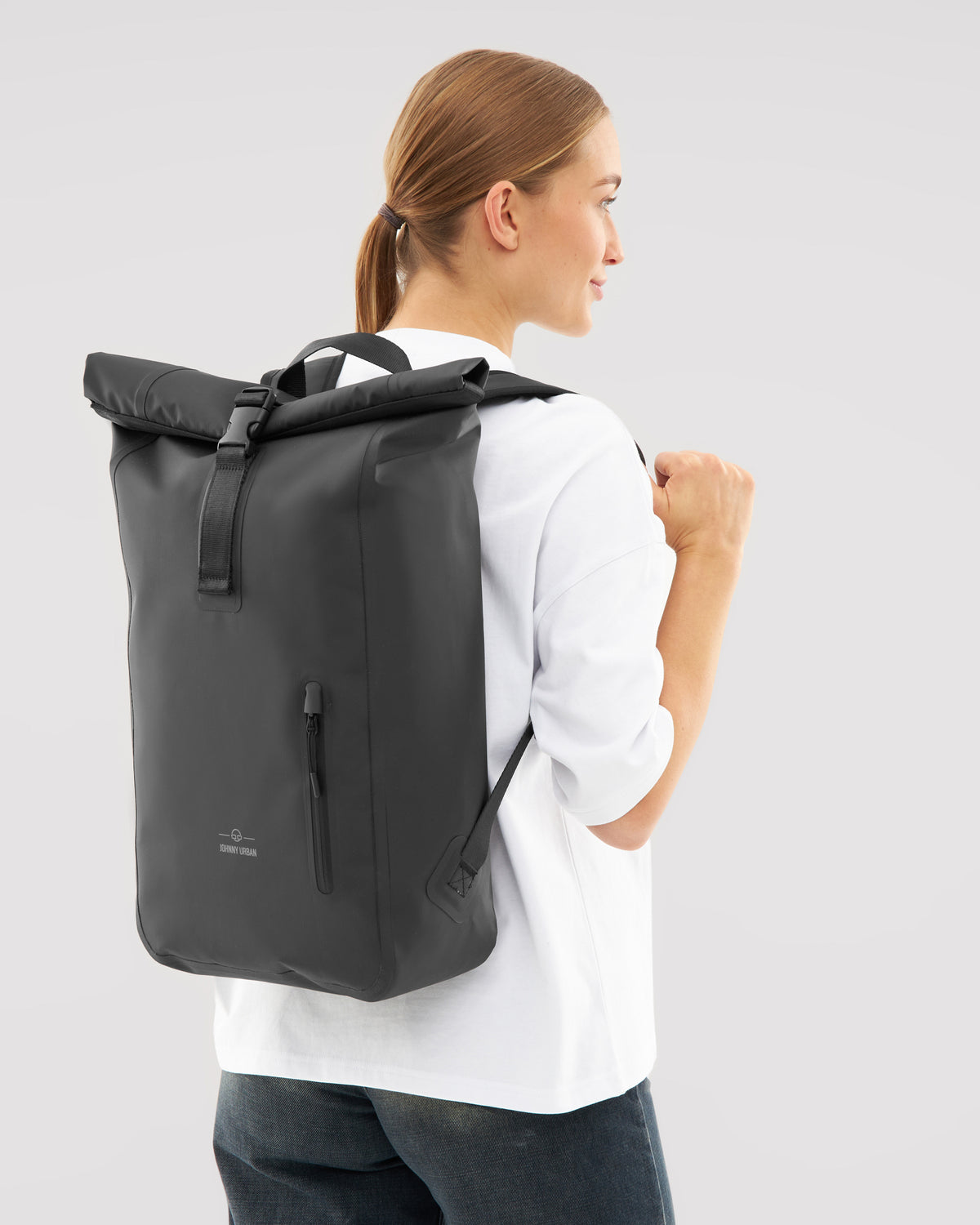 Frau trägt schwarzen wasserfesten Rolltop Rucksack 'Conor' von Johnny Urban