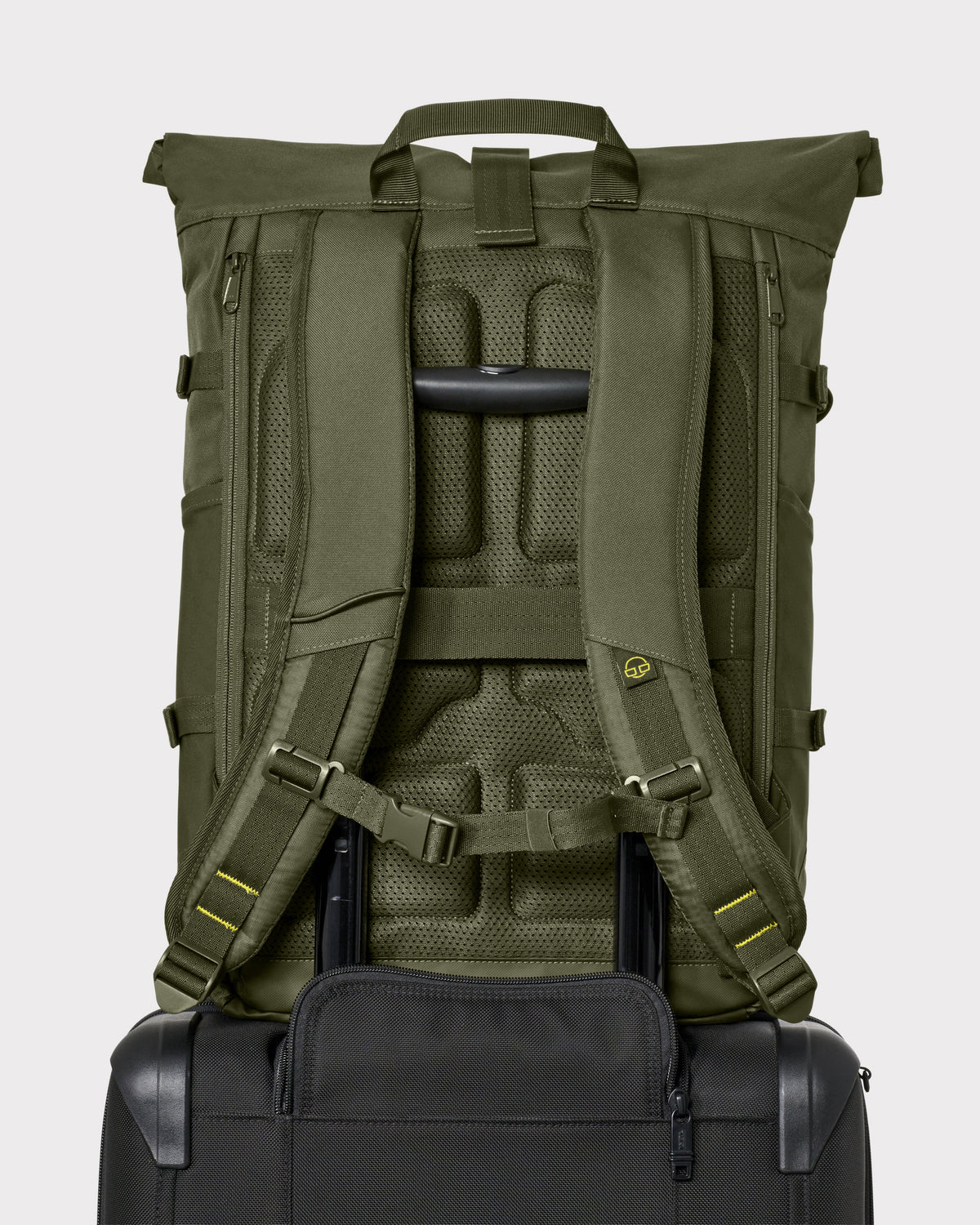 Rückansicht des olivgrünen Rolltop-Rucksacks 'Allen Large Move' auf einem Trolleygriff