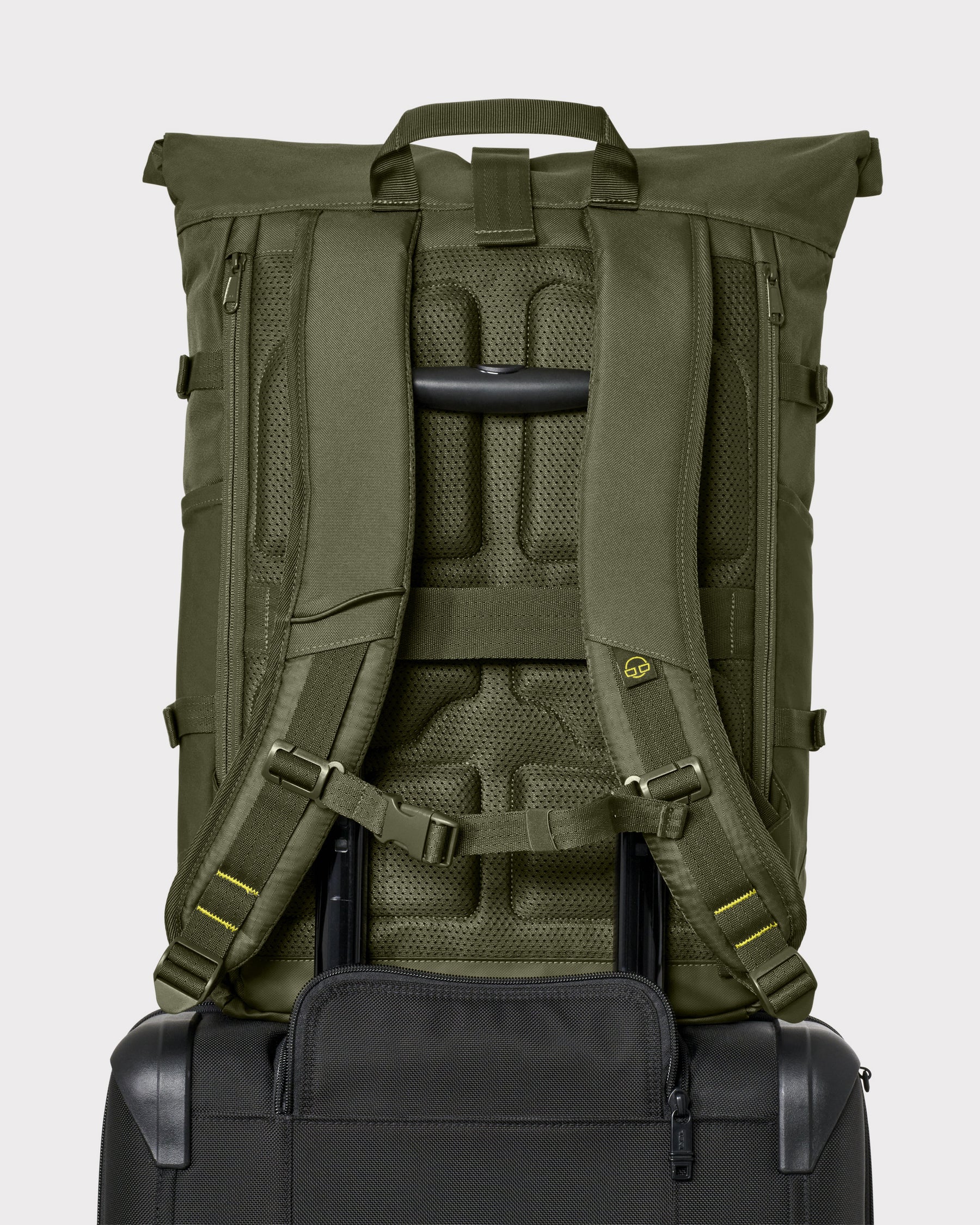 Rückansicht des olivgrünen Rolltop-Rucksacks 'Allen Large Move' auf einem Trolleygriff