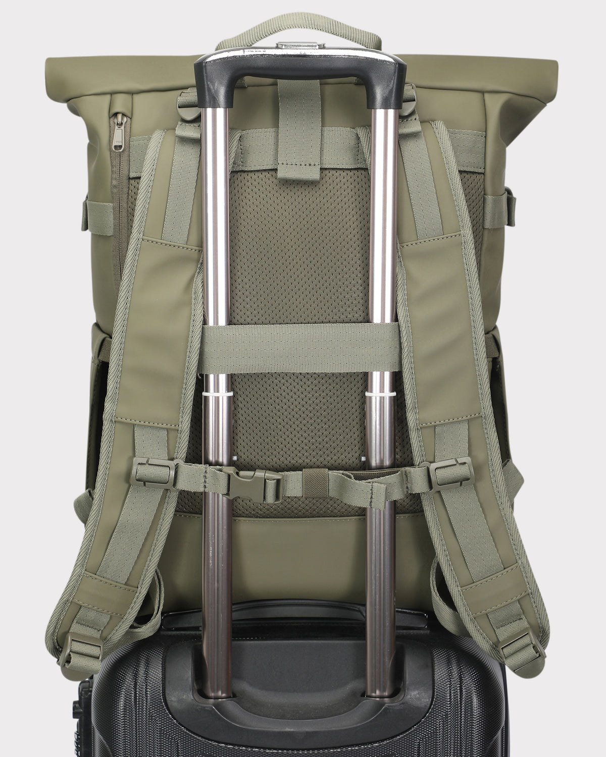 Rückansicht des Rolltop Rucksacks Harvey Large in Oliv, befestigt an einem Teleskopgriff eines schwarzen Handgepäckkoffers