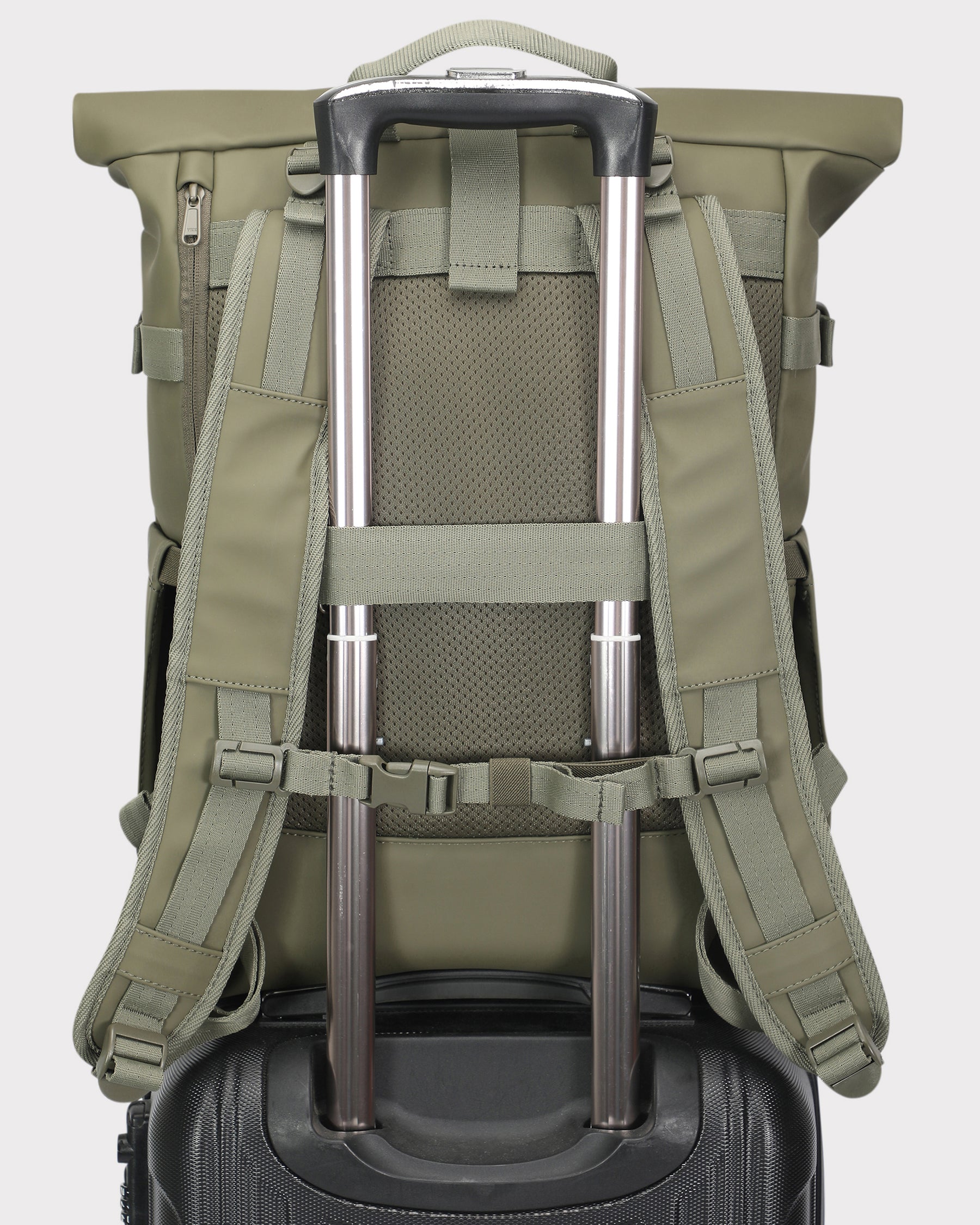 Rückansicht des Rolltop Rucksacks Harvey Large in Oliv, befestigt an einem Teleskopgriff eines schwarzen Handgepäckkoffers