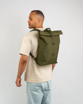 Mann trägt olivegrünen Rolltop-Rucksack 'Robin Medium' von Johnny Urban, trägt helles T-Shirt und Jeans