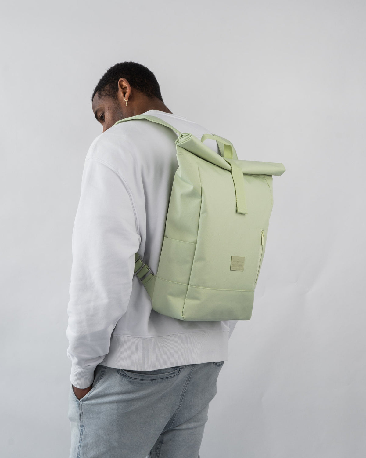 Mann von hinten mit hellem Rolltop-Rucksack 'Robin Medium' in Limettengrün