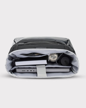 Schwarzer Rolltop Rucksack 'Ashton' von Johnny Urban, geöffnet und mit Laptop, Buch, und Wasserflaschen im Innenfach