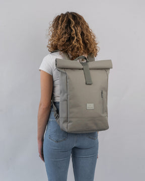 Frau mit lockigem Haar trägt den Johnny Urban Rolltop Rucksack 'Robin Medium' in desert-grey, Rückenansicht