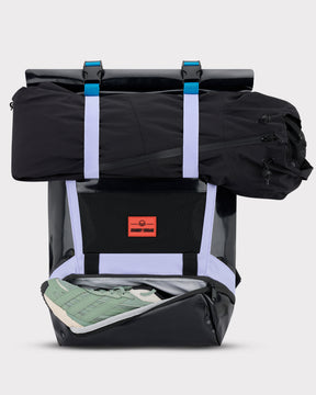 Rolltop Rucksack 'Ashton' in Schwarz mit fliederfarbenen Riemen, geöffnetes Schuhfach mit grün-weißen Schuhen