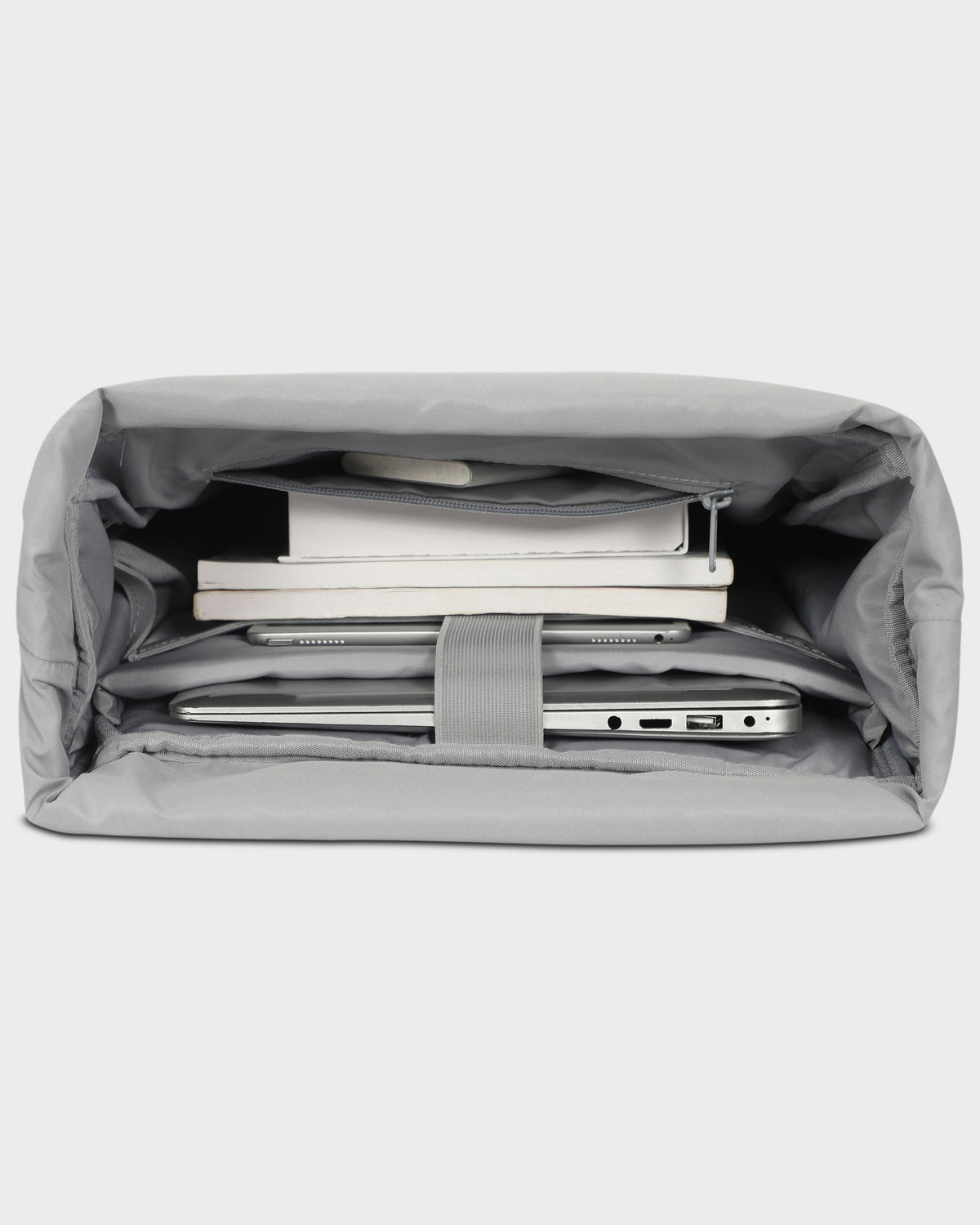 Innenansicht des grauen Rolltop Rucksack Harvey Large mit mehreren Fächern und ausgestatteten Laptop, Tablet und Büchern