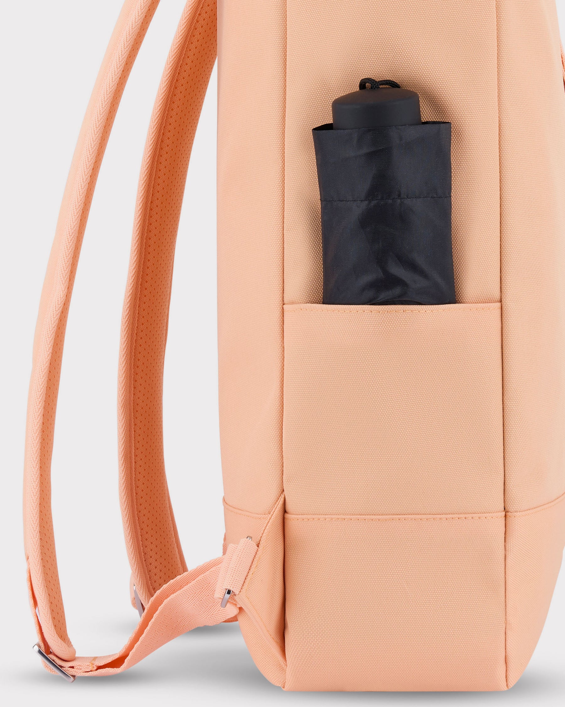 Seitentasche des Rolltop Rucksacks 'Robin Medium' in Pfirsich mit schwarzem Regenschirm darin
