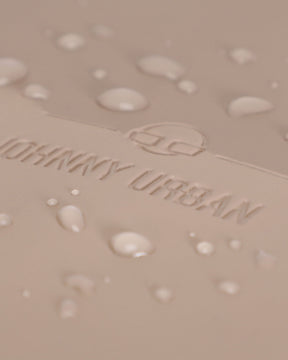 Nahe Aufnahme des beigen wasserdichten Materials mit dem eingeprägten Johnny Urban Logo und Wassertropfen