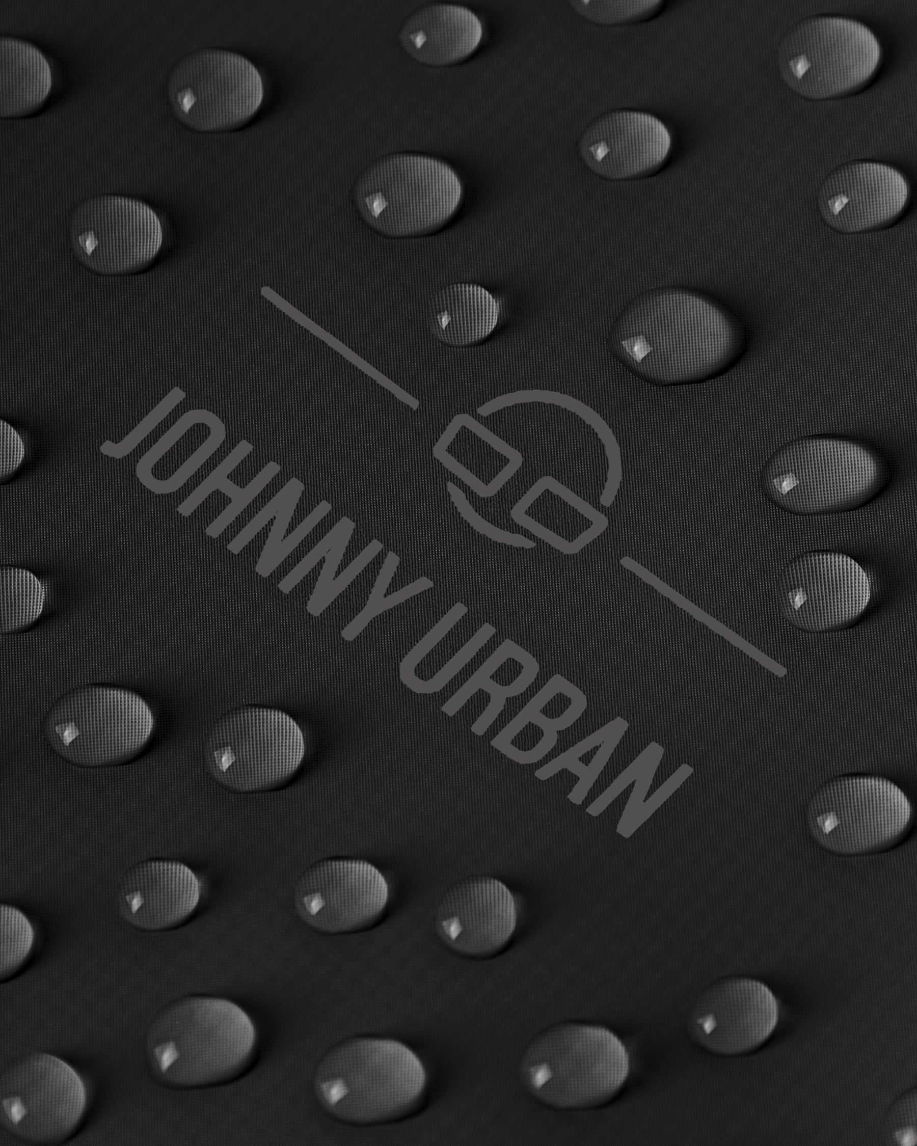 Nahaufnahme von Wassertröpfchen auf dem schwarzen Material des rolltop Rucksacks 'Conor' von Johnny Urban