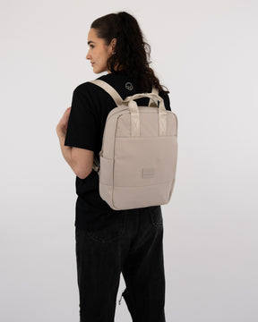Frau mit beigem Johnny Urban Rucksack 'Jona Medium' und schwarzem T-Shirt und Hose