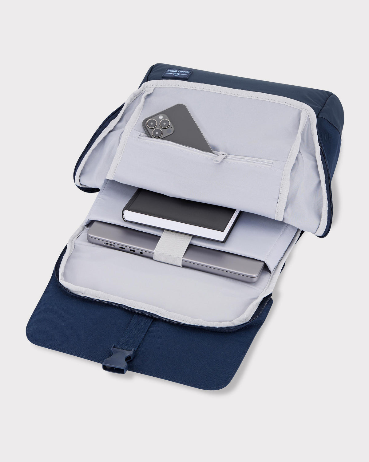 Offener blauer Rucksack 'Mika' von Johnny Urban mit einem Notebook, einem Notizbuch und einem Smartphone in Innenfächern