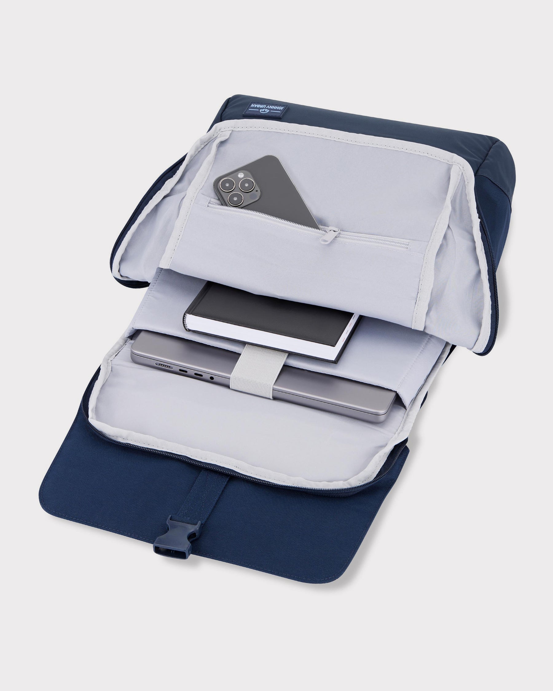 Offener blauer Rucksack 'Mika' von Johnny Urban mit einem Notebook, einem Notizbuch und einem Smartphone in Innenfächern