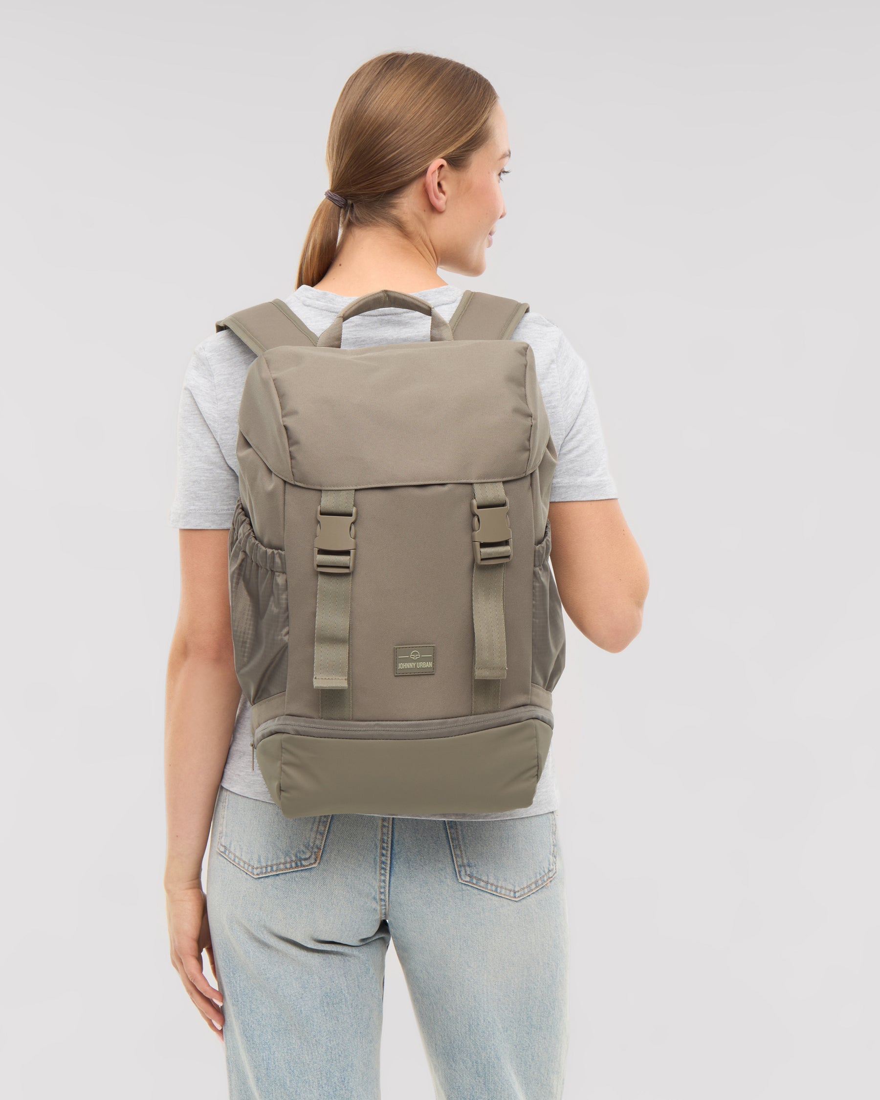 Frau trägt Rucksack 'Nico' in desert grey, Rückansicht, mit verstellbaren Schulterriemen und seitlichen Taschen