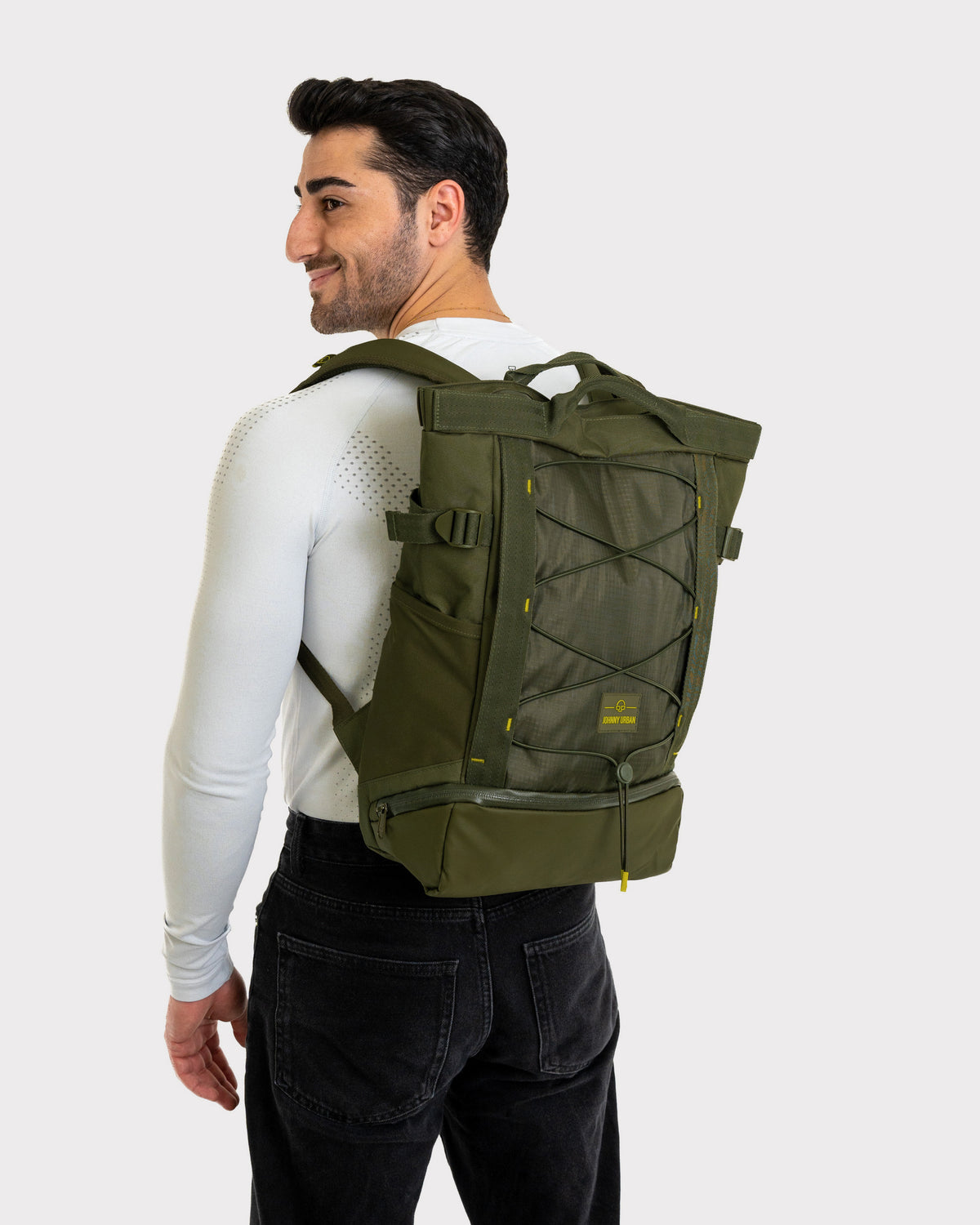Mann trägt olivgrünen Johnny Urban Rucksack 'Harper' mit Frontschnürung und graviertem Logo
