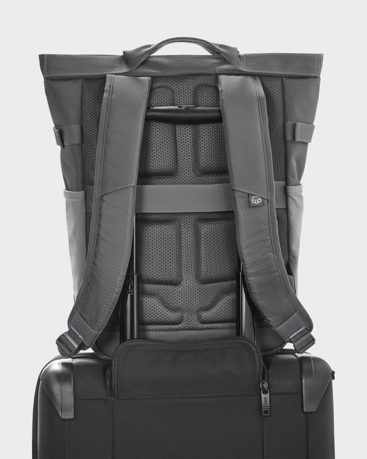 Rucksack 'Harper' in Grau mit gepolstertem Rücken und Schultergurten, auf schwarzem Trolley-Griff aufgesetzt