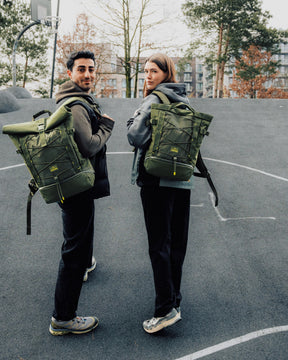Zwei Personen, jeweils mit olivgrünem Rucksack 'Harper', auf einem urbanen Basketballplatz
