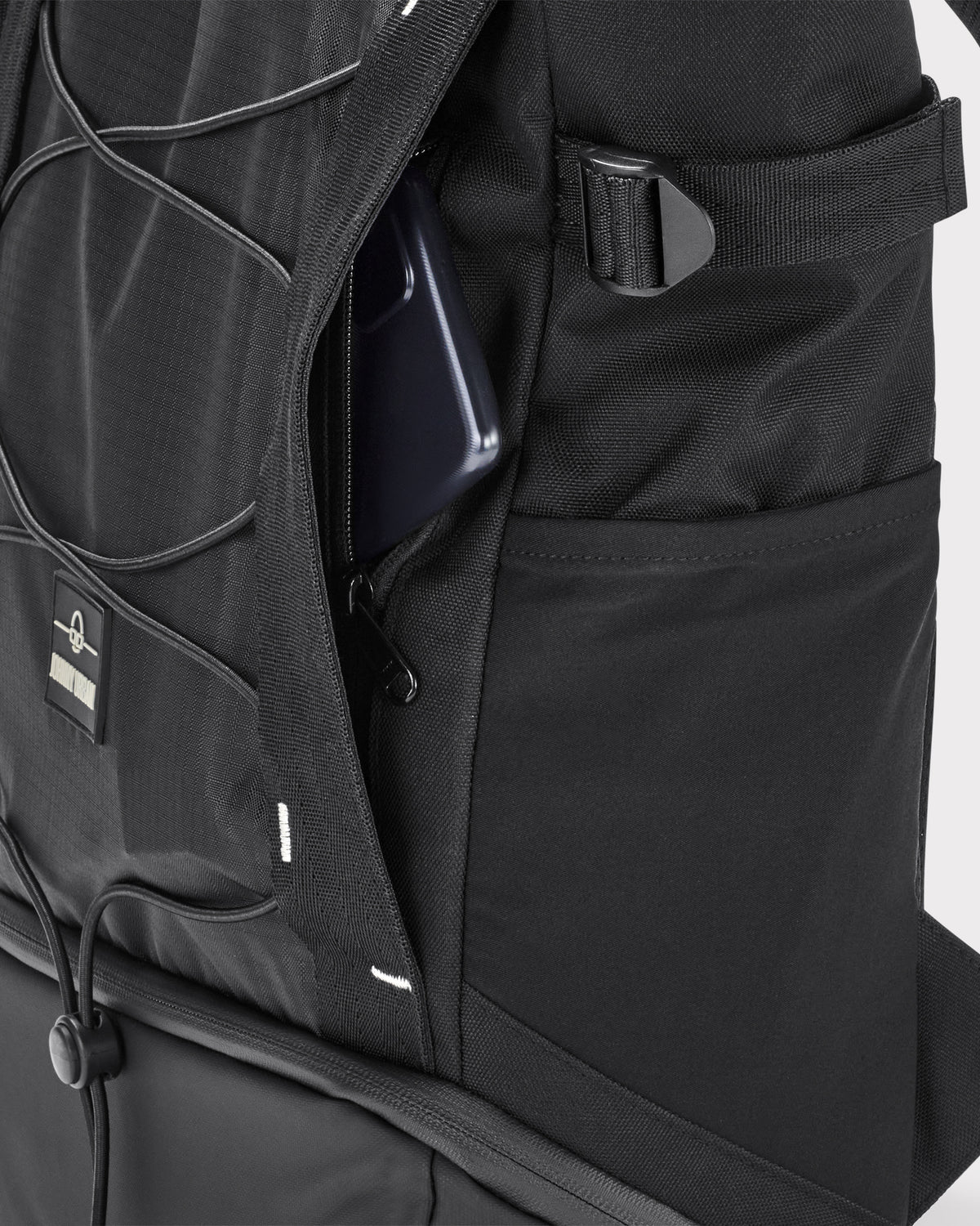 Schwarzer Johnny Urban Rucksack 'Harper' mit geöffnetem Geheimfach und Smartphone darin