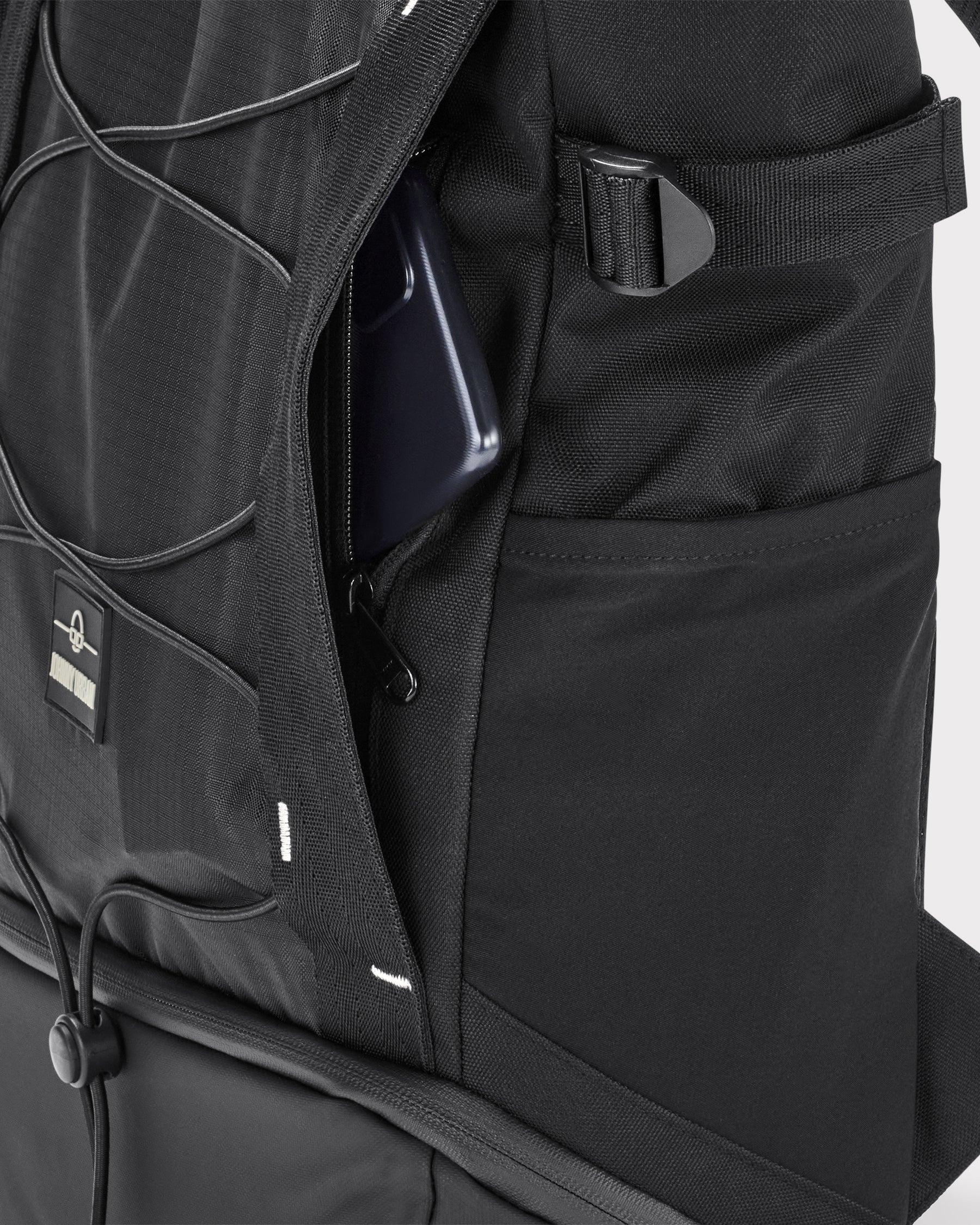 Schwarzer Johnny Urban Rucksack 'Harper' mit geöffnetem Geheimfach und Smartphone darin