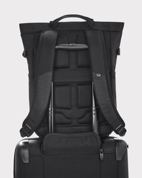 Schwarzer Rucksack 'Harper' von Johnny Urban auf einem schwarzen Trolley befestigt, gezeigt von hinten mit gepolstertem Rücken und verstellbaren Schultergurten